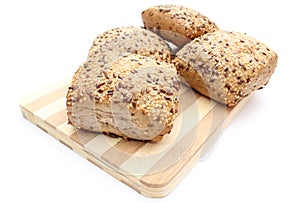 Wholemeal rolls on cutting board isolated on white background