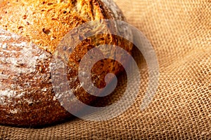 Wholemeal sourdough bread isolated on burlap cloth.