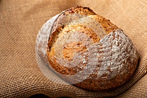 Wholemeal sourdough bread isolated on burlap cloth.