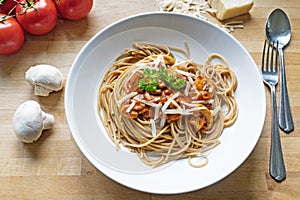 Wholemeal spaghetti with sauce of tomatoes, mushrooms and parmes