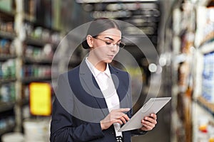 Wholesale and logistics concept. Manager using tablet computer in warehouse