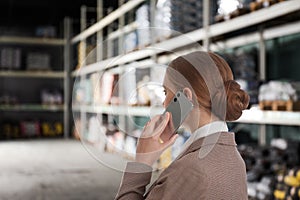 Wholesale and logistics. Manager talking on phone in warehouse