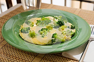 Wholesome breakfast. omelet with broccoli on green plate