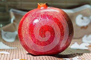 Wholesome ripe pomegranate fruit in red scabrous peel.