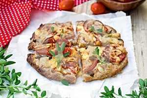 Wholewheat pizza with tomatoes, cheese and herbs