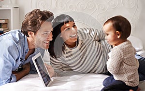 Whos that pretty girl on the screen. a happy mother and father showing their baby daughter a digital tablet.