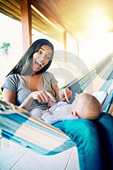 Whos the smartest little boy in the world. a cheerful young mother relaxing on a hammock with her infant son outside at