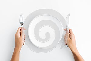 Whte plate with silver fork and knife on white background