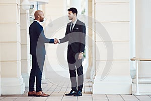 Why do it alone when you can be stronger together. two businessmen shaking hands in the city.