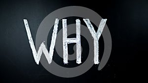 Why? Hand writes question by chalk on a blackboard. Written is heated. Timelapse