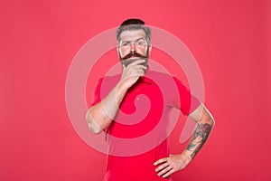 Why so serious. Serious look of brutal hipster. Bearded man think red background. Serious and thoughtful. Thinking on