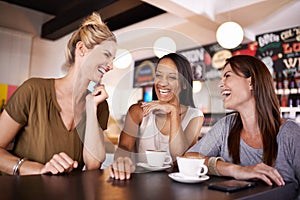 This is why were friends. three friends having fun at a coffee shop together.