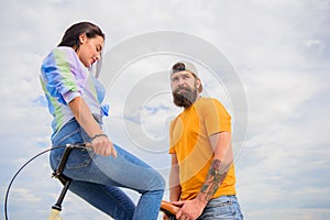 Why women more attracted biker guys. Girl sit on handlebar of his bike. Man bearded hipster rides girlfriend on his bike