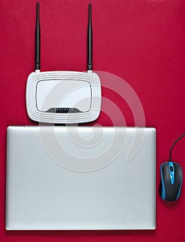 Wi fi router, laptop, pc mouse on a red background