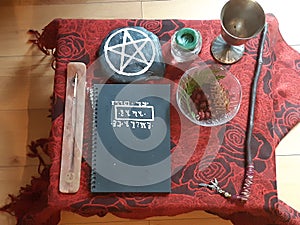 Wiccan altar, fall altar setup, pagan magic ritual altar design. Book of shadows, wand, incense and candles photo