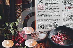 Wiccan witch altar with an open book of shadows with hand written spell in it, ready for spell casting