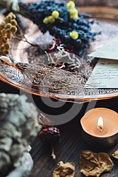 Wiccan witch altar with various random objects on a dark brown wooden table