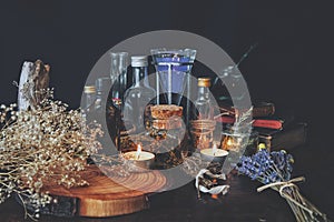 Wiccan witch apothecary - various ingredients, potions and dried herb bottles and jars for magick, placed on an altar.