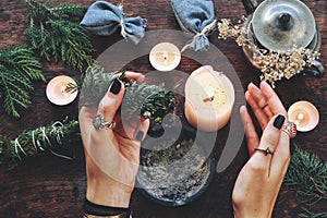 Wiccan witch holding cedar cleansing stick to cleanse the energy at her altar