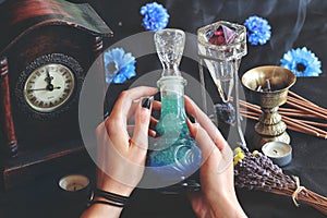 Wiccan witch holding a lucid dreaming good night potion in her hands at her altar.