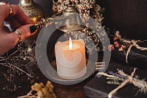 Wiccan witch putting out a white candle flame with antique brass gold colored wick snuffer