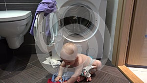 Wicked baby boy doing mess with laundry in bathroom