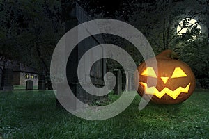 A wicked grinning halloween pumpkin lies in a cemetery