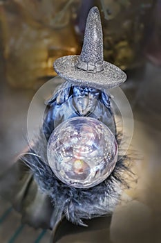 Wicked witch Halloween decoration with crystal ball and sparkly hat against bokeh background