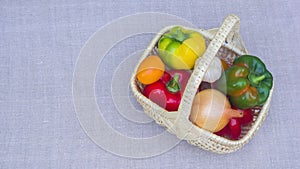 The wicker basket appears on a linen tablecloth and is then filled with ripe vegetables. Stop motion animation