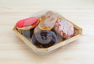 Wicker basket with assorted donuts on wood table top