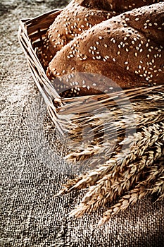 Wicker basket breadstick rye ears on sacking background