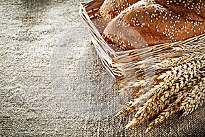 Wicker basket breadstick wheat ears on sacking background