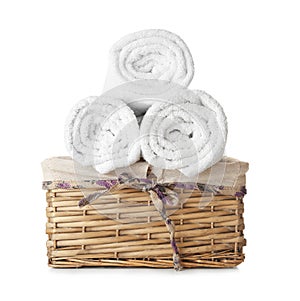 Wicker basket with clean rolled towels on white background