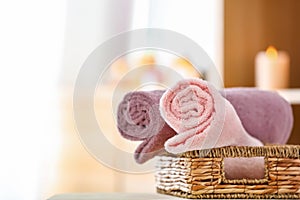 Wicker basket with clean soft towels on table in room