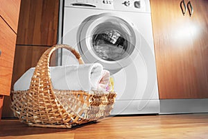Wicker Basket with Clean Towels on the Floor by the Washing Machine with Laundry. House Interior Laundry Room. Wood Interior