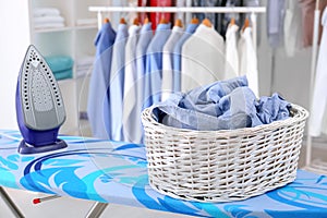 Wicker basket with clothes on ironing board