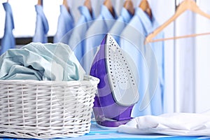 Wicker basket with clothes on ironing board