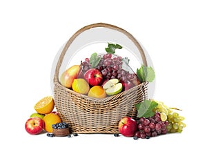 Wicker basket with different fruits and berries on white background