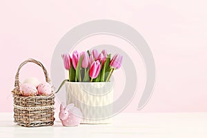 Wicker basket with Easter eggs and ceramic rabbit figure