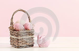 Wicker basket with Easter eggs and ceramic rabbit figure