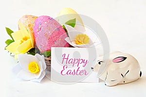 Wicker basket with Easter eggs with spring flower.