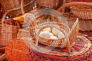 Wicker basket in the form of a duck filled with wooden eggs close-up