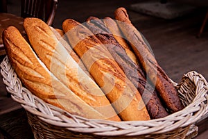 Wicker basket full of baguettes, tasty delicious crusty bread in bakery shopfront