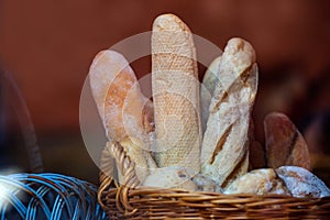 Wicker basket full of baguettes, tasty delicious crusty bread in bakery shopfront