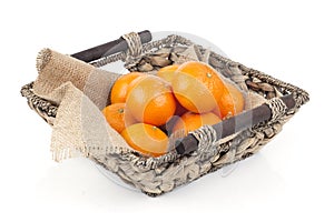 Wicker basket full of fresh orange fruits