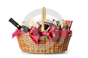 Wicker basket full of gifts isolated on white