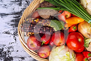 Wicker basket full of vegetables and fruits top view. Autumn and harvest time. Space for text