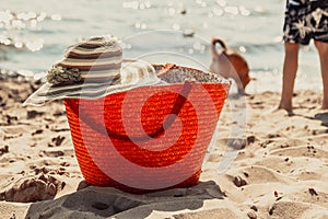 Wicker basket handbag bag and hat on summer beach.