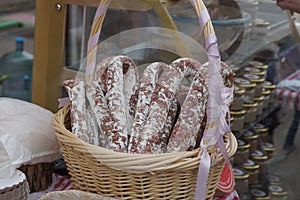 Wicker basket of italian sausage - traditional handmade organic salami in market. Gastronomic products for gourme