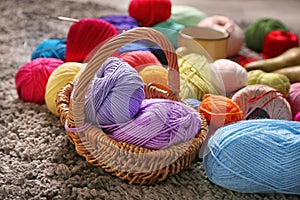 Wicker basket with knitting yarn on carpet